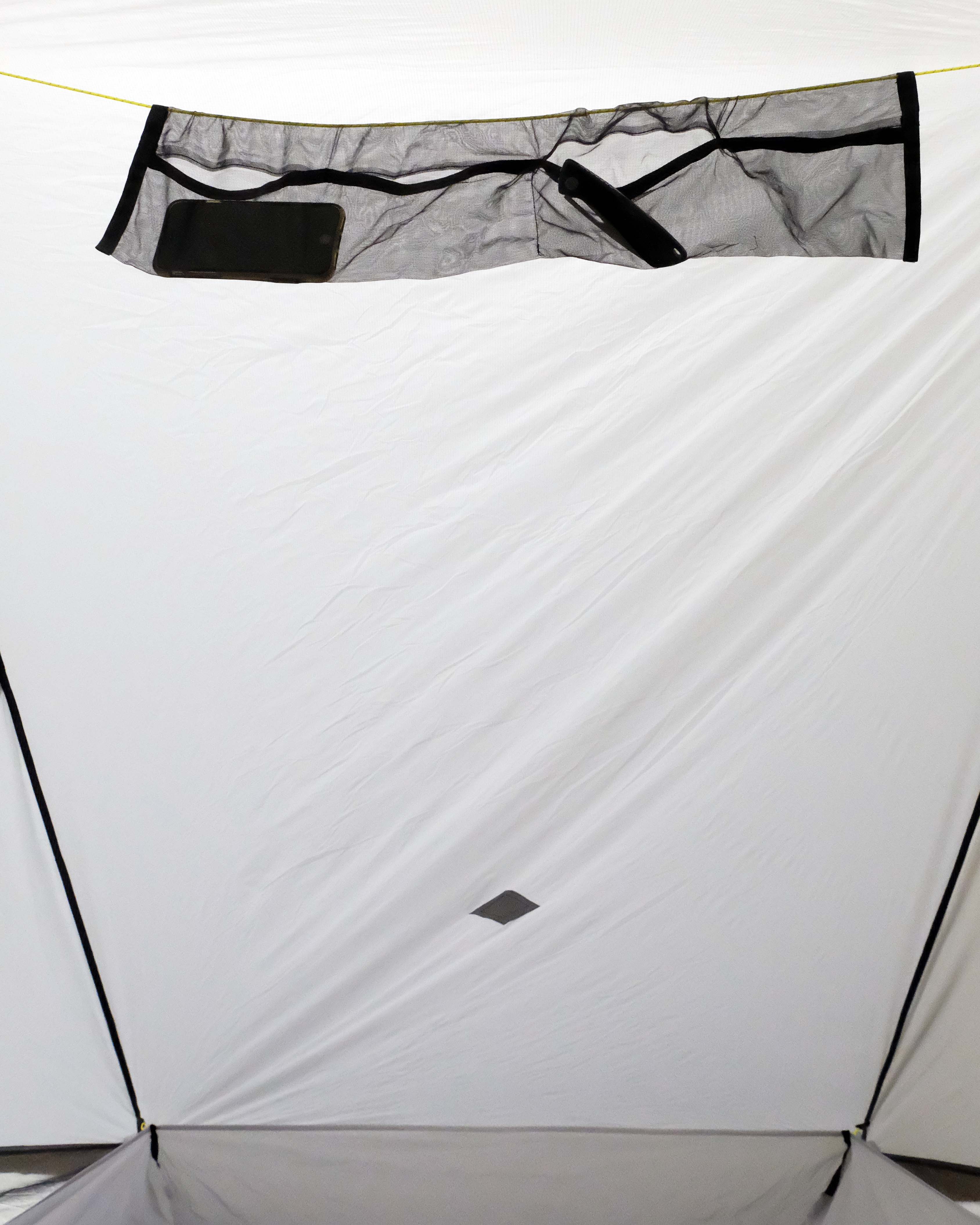 Internal gear loft inside of the Owyhee shelter. Holding a phone and a pocket knife.